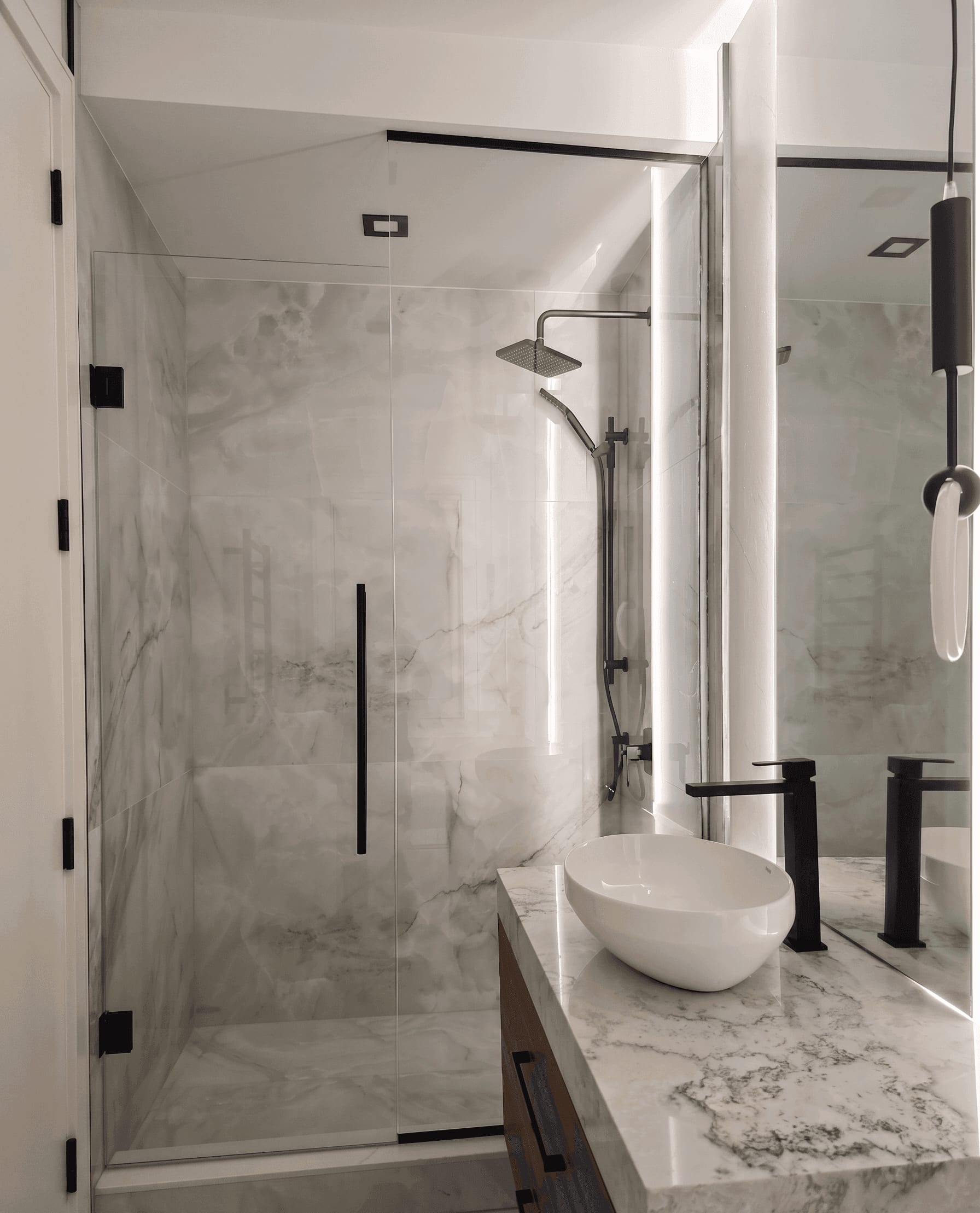 Frameless glass shower enclosure with matte black hardware and marble tile surround — custom glass shower installation by Built By Glass, GTA