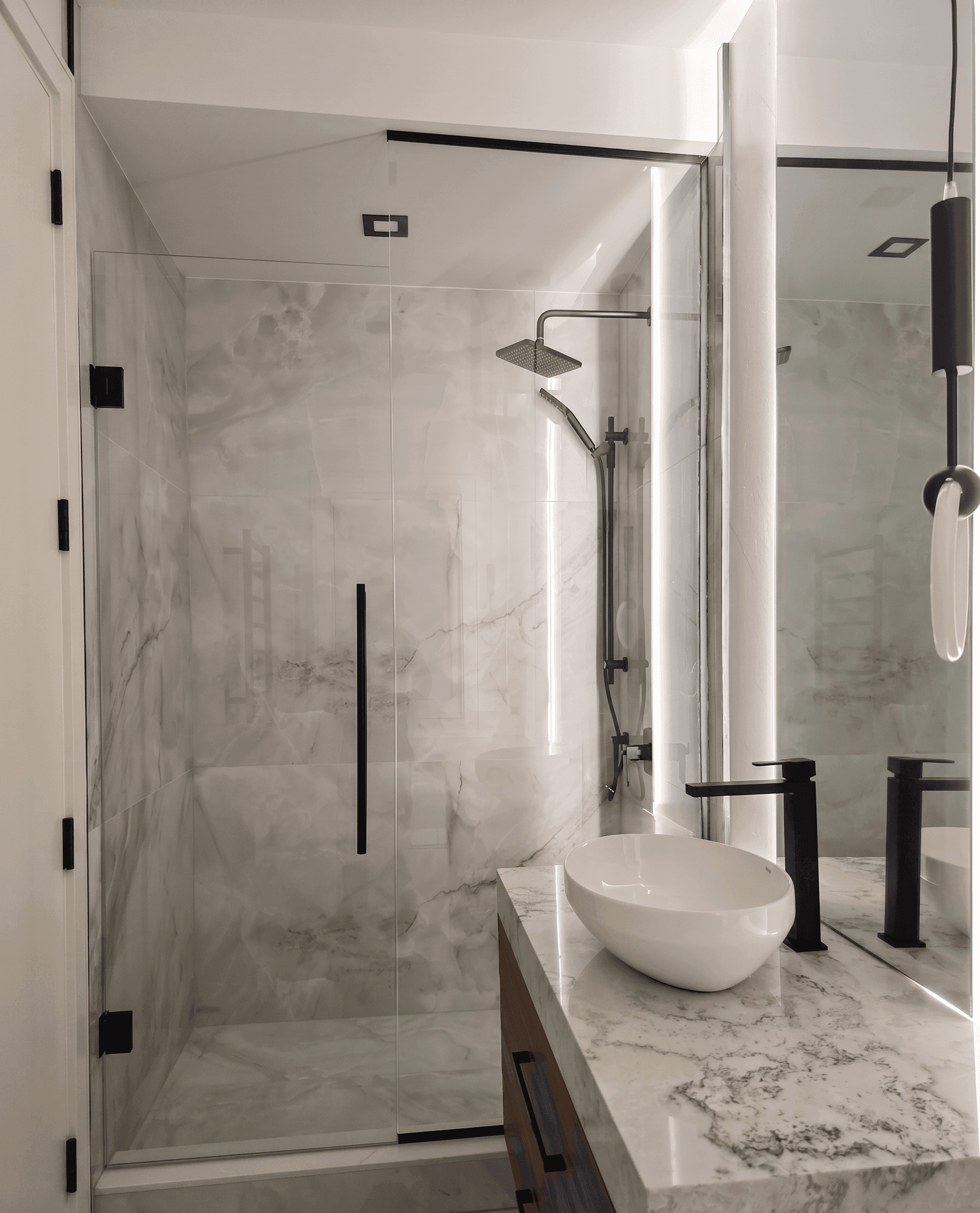 Frameless glass shower enclosure with matte black hardware and marble tile surround — custom glass shower installation by Built By Glass, GTA