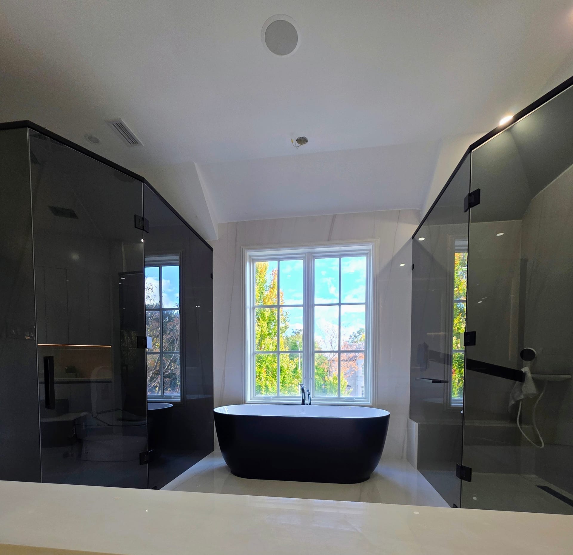 10mm smoked grey tempered glass shower enclosure with matte black architectural hardware — custom glass installation by Built By Glass in Pickering, Ontario